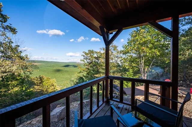 a view of a balcony with chairs and wooden floor