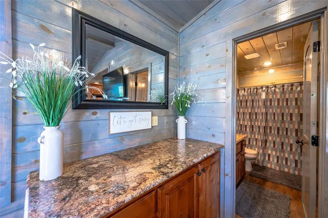 a kitchen with a sink a microwave a potted plant and a wooden floor