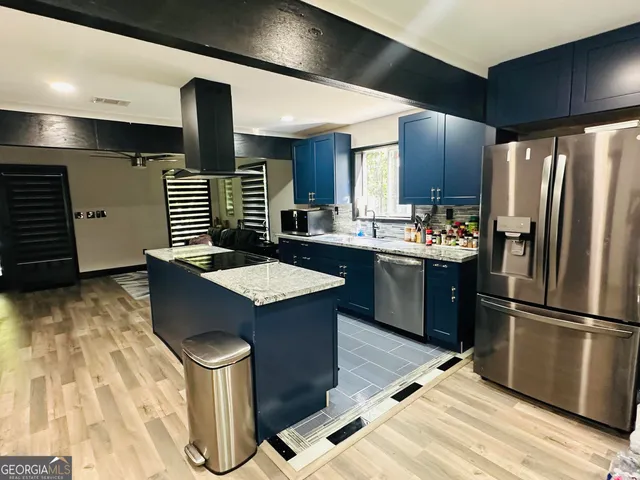 a kitchen with stainless steel appliances kitchen island granite countertop a sink and cabinets
