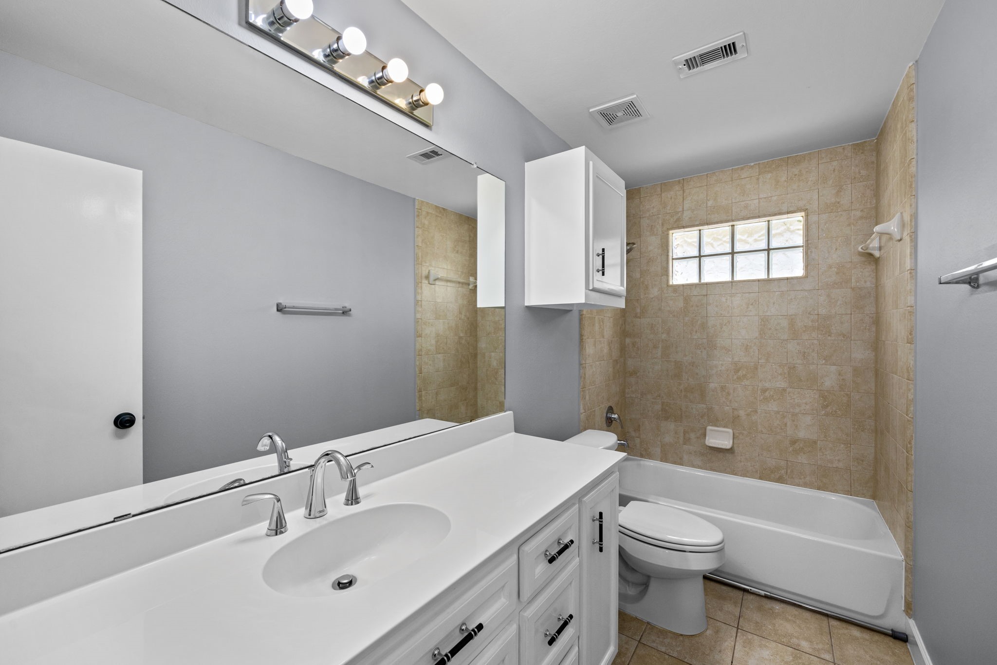 5951 S Loop East, Unit 50 Houston, TX 77033 - Photo 20 of 23 a bathroom with a toilet a sink a mirror and a bathtub