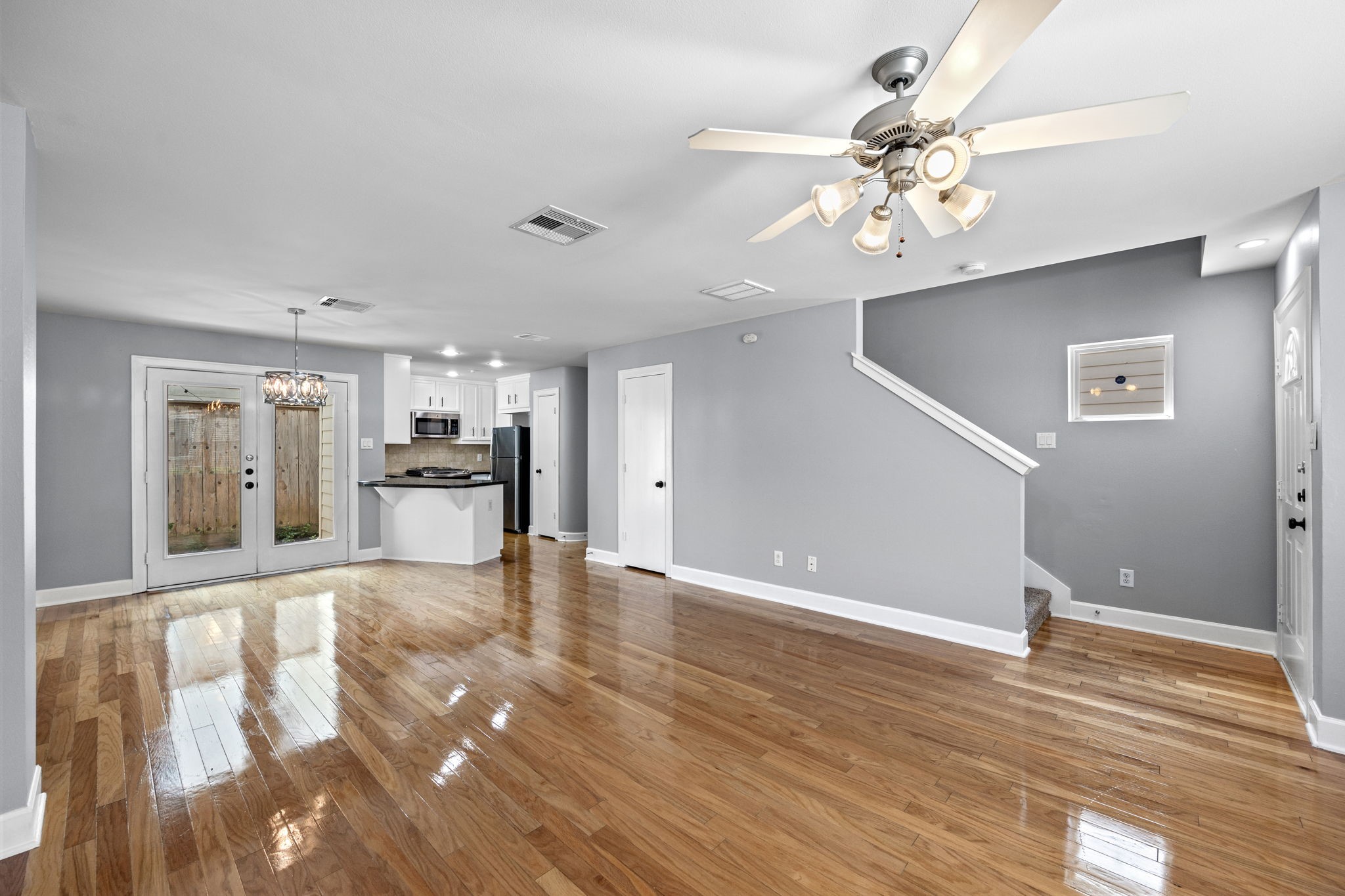 5951 S Loop East, Unit 50 Houston, TX 77033 - Photo 5 of 23 a view of an empty room with wooden floor and a kitchen