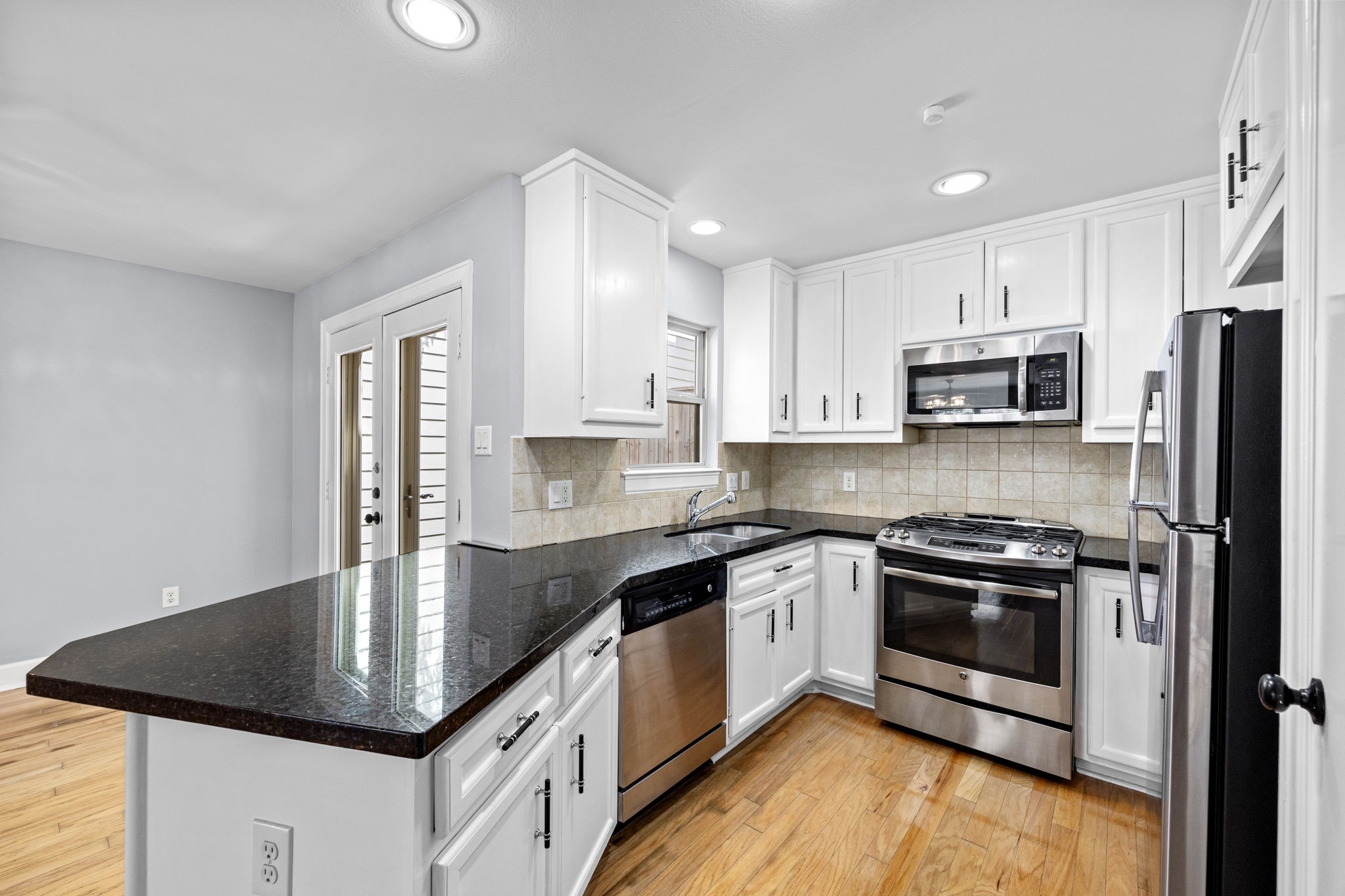5951 S Loop East, Unit 50 Houston, TX 77033 - Photo 9 of 23 a kitchen with stainless steel appliances granite countertop a sink stove microwave and refrigerator