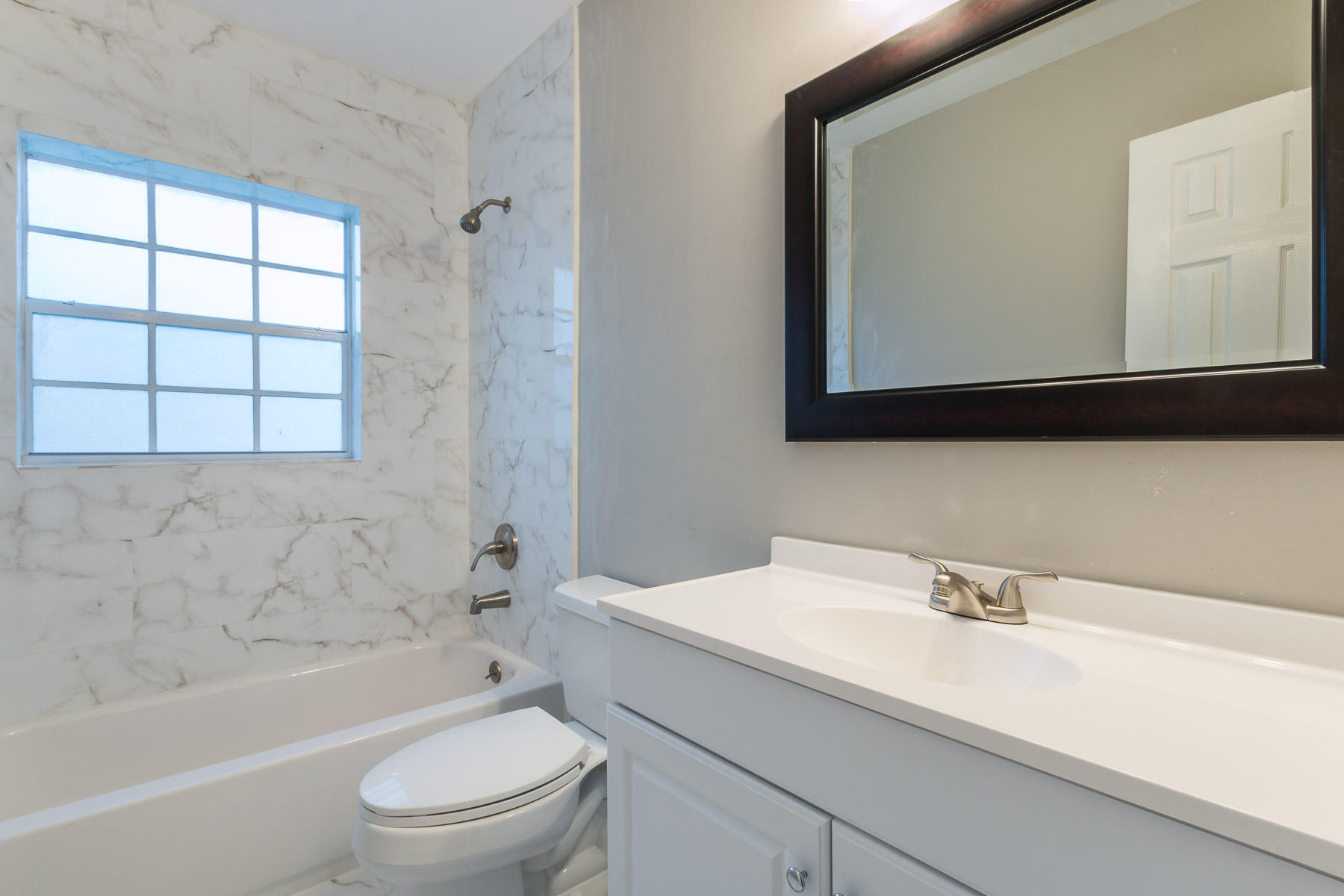 9222 Southwest 1st Place Boca Raton, FL 33428 - Photo 11 of 23 a bathroom with a sink a toilet a mirror and bathtub
