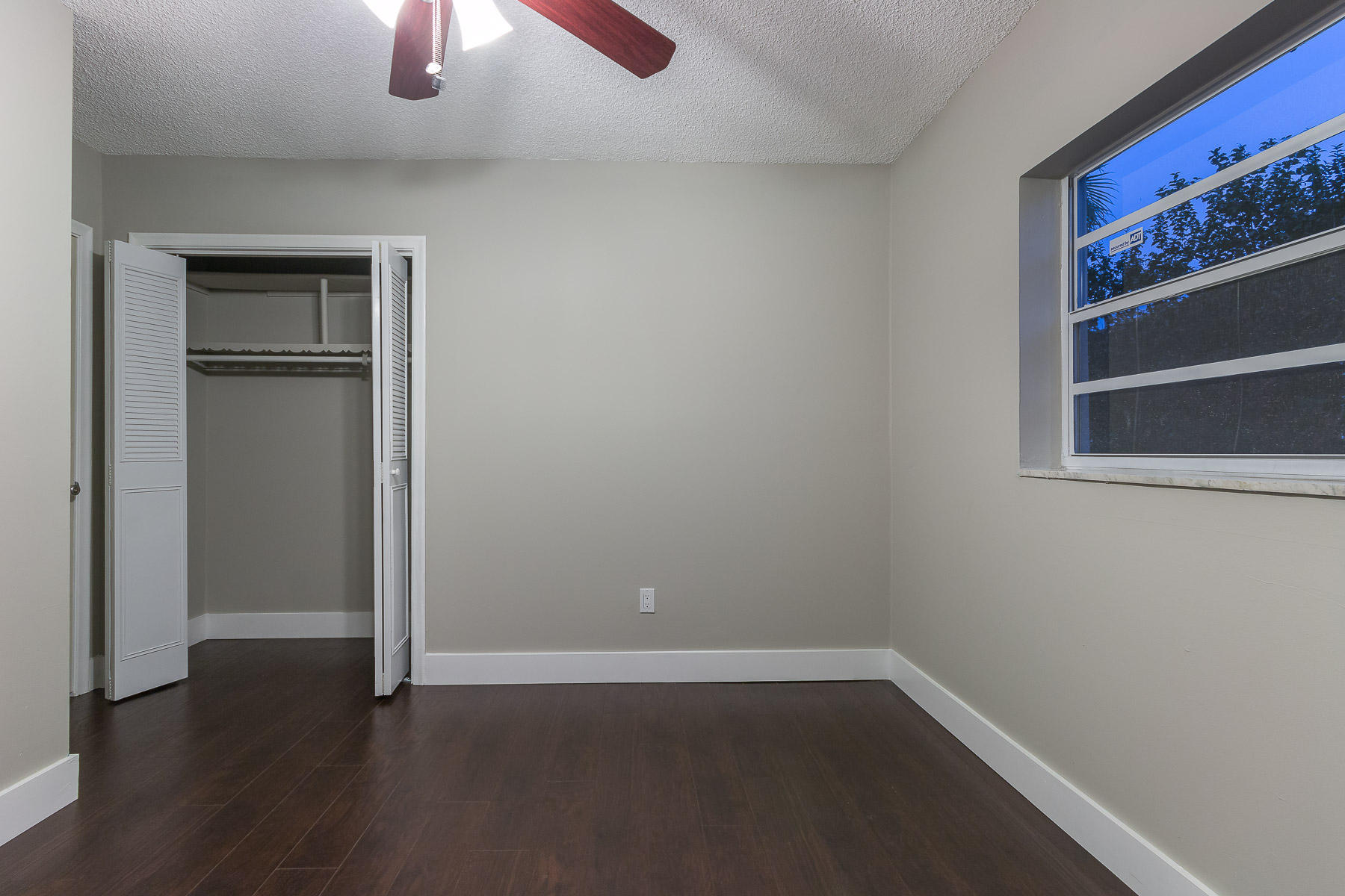 9222 Southwest 1st Place Boca Raton, FL 33428 - Photo 17 of 23 a view of an empty room with wooden floor closet and a window