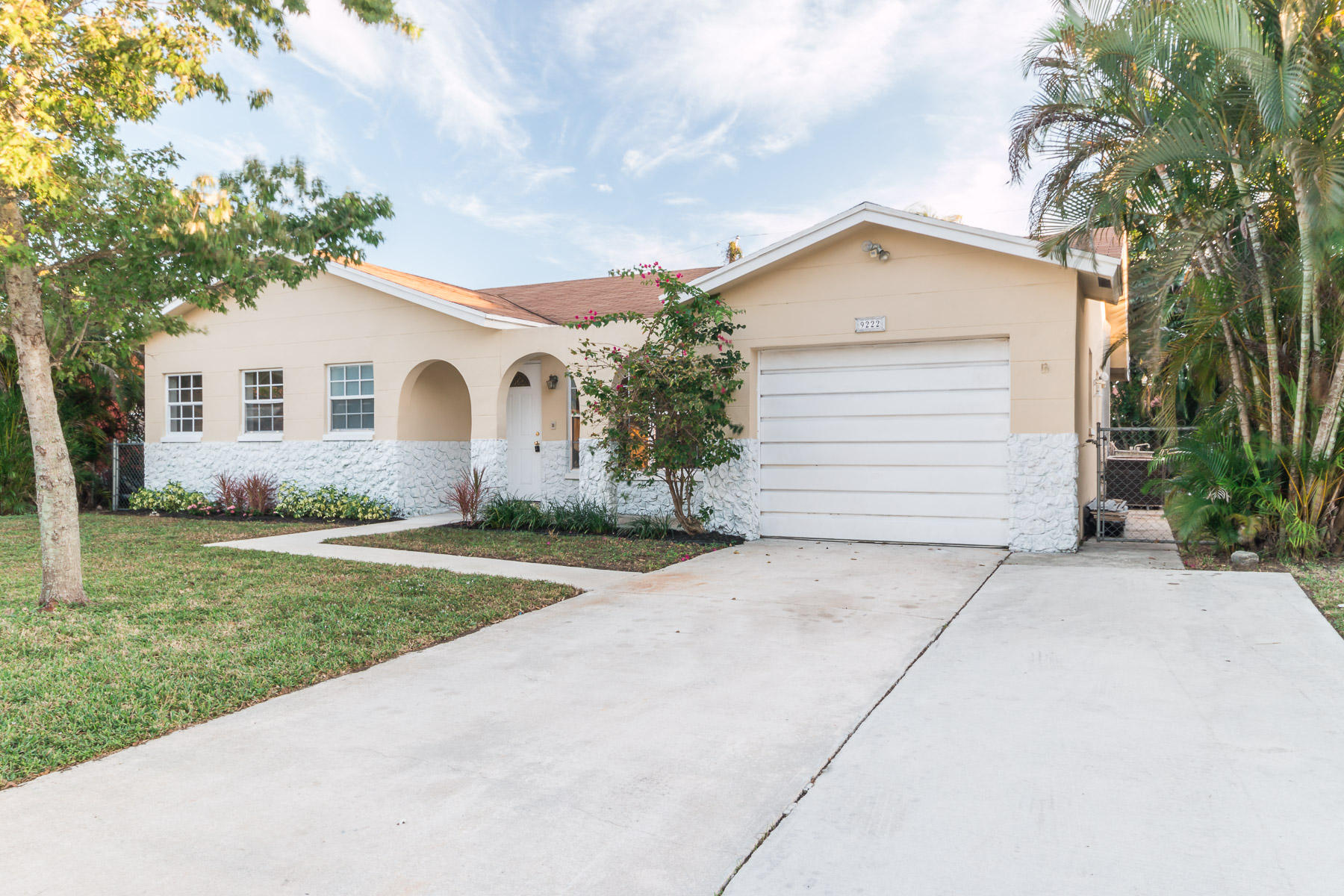 9222 Southwest 1st Place Boca Raton, FL 33428 - Photo 2 of 23 a view of a white house next to a yard and palm trees