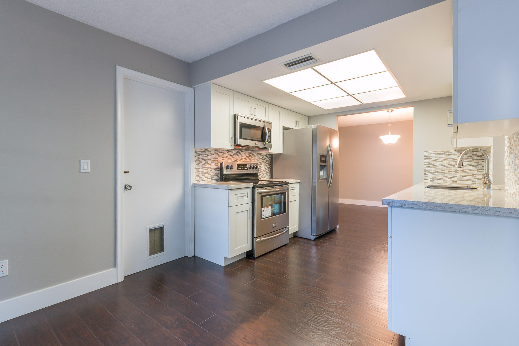 9222 Southwest 1st Place Boca Raton, FL 33428 - Photo 5 of 23 a kitchen with stainless steel appliances a stove a sink and a refrigerator