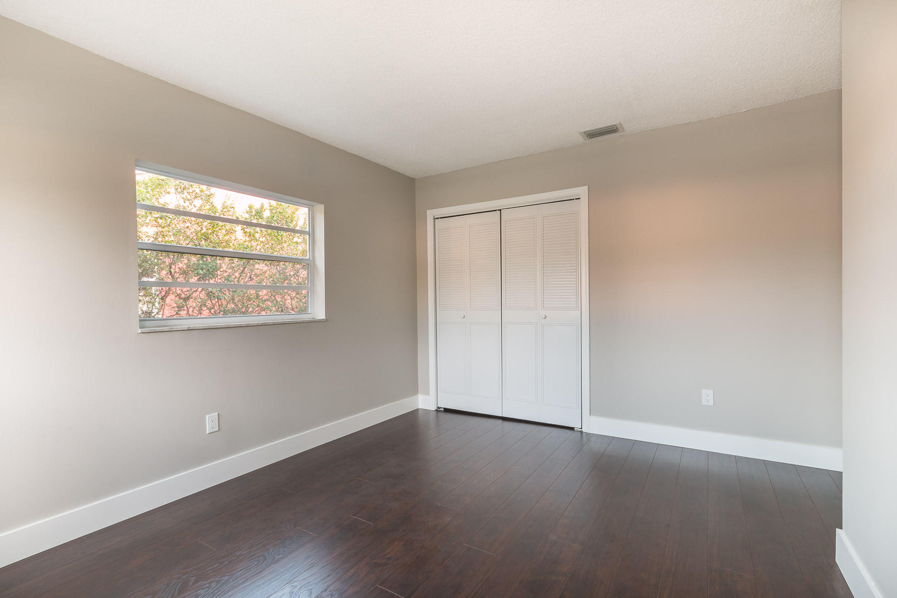 9222 Southwest 1st Place Boca Raton, FL 33428 - Photo 10 of 23 an empty room with wooden floor and windows