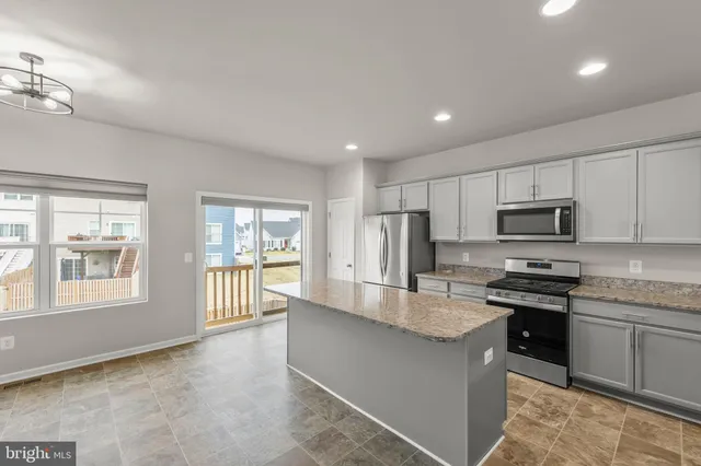 a kitchen with granite countertop a sink stove and refrigerator