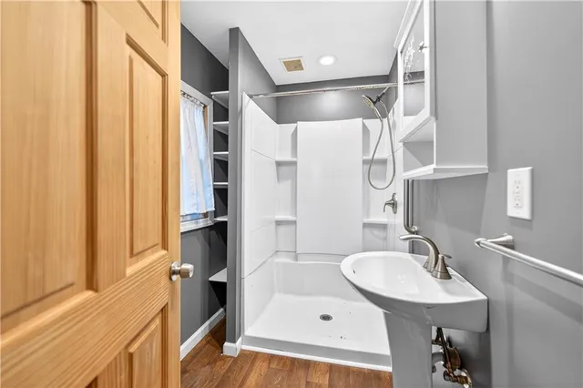 a bathroom with a sink a mirror and a shower