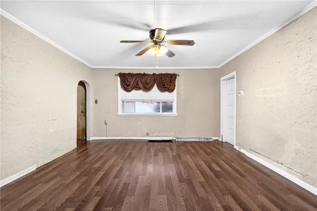 a view of an empty room with window and wooden floor