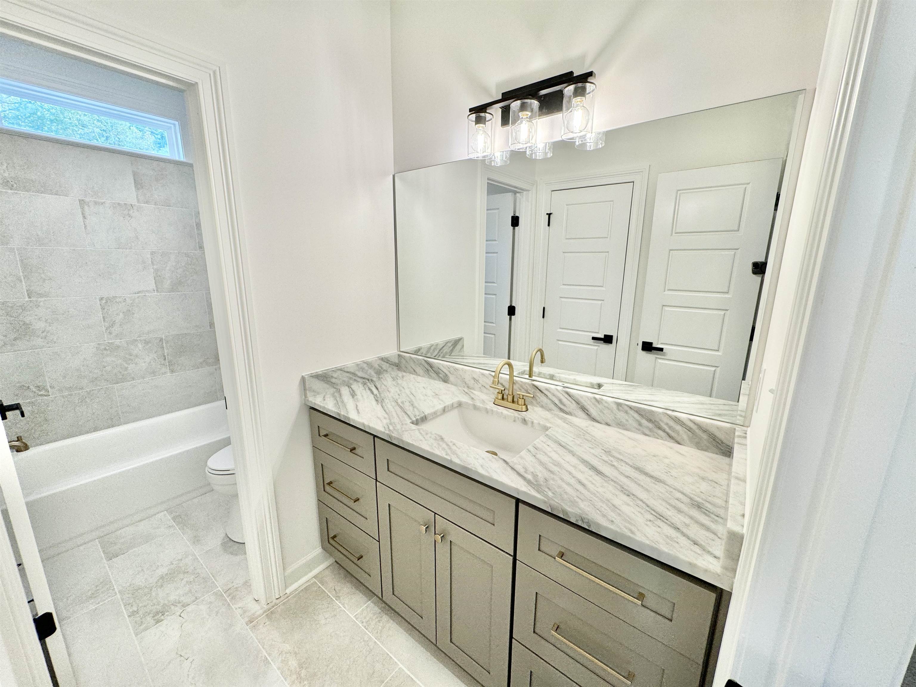 17 Edith Lane Atoka, TN 38004 - Photo 31 of 36 a bathroom with a granite countertop sink a mirror and a bathtub