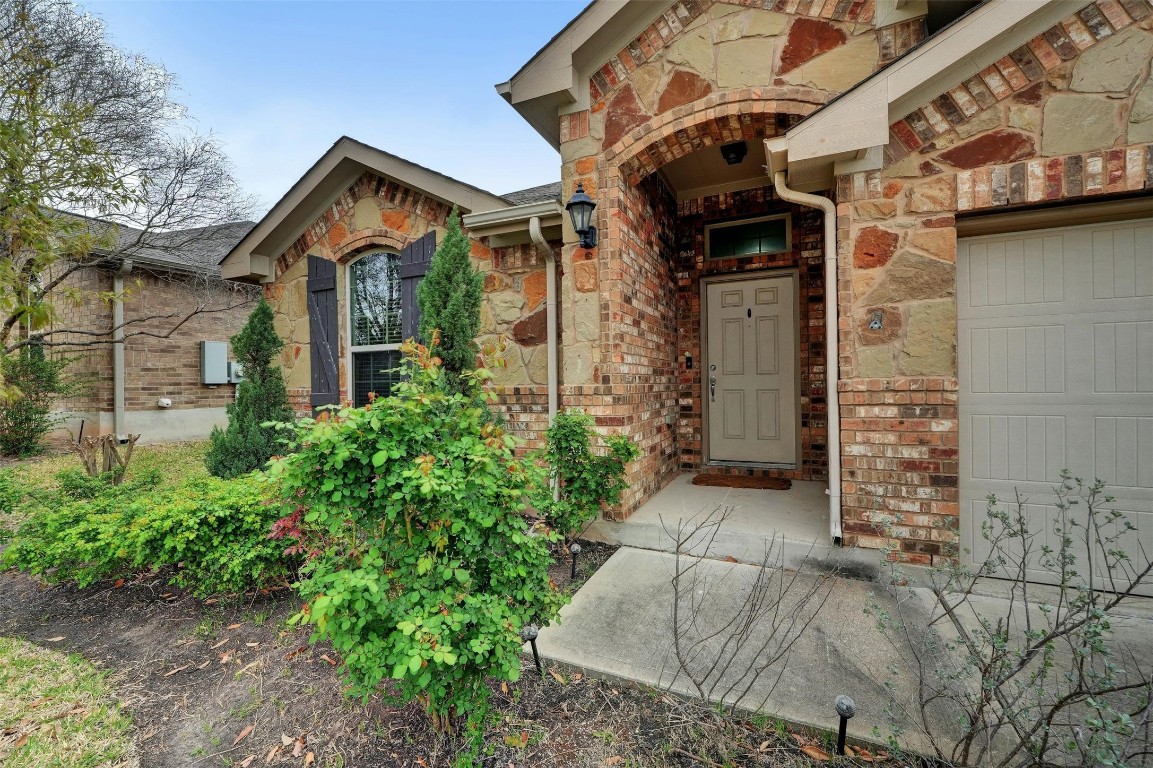 Lovely curb appeal with picture perfect stone masonry, mature landscaping, vibrant young shade trees, and a two-car garage.