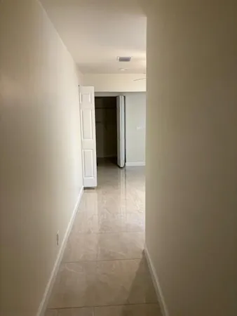 a view of an empty room with a chandelier fan