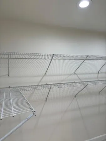 an empty room with closet and a ceiling fan