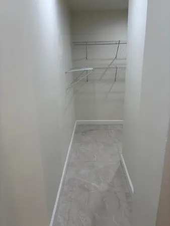 an empty room with a ceiling fan and a window