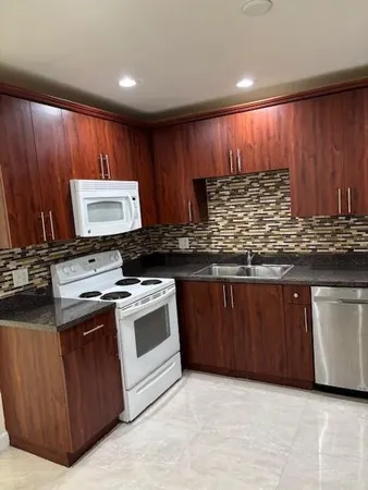 a kitchen with stainless steel appliances granite countertop a refrigerator a sink and a stove