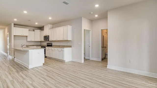 a kitchen with white cabinets and stainless steel appliances