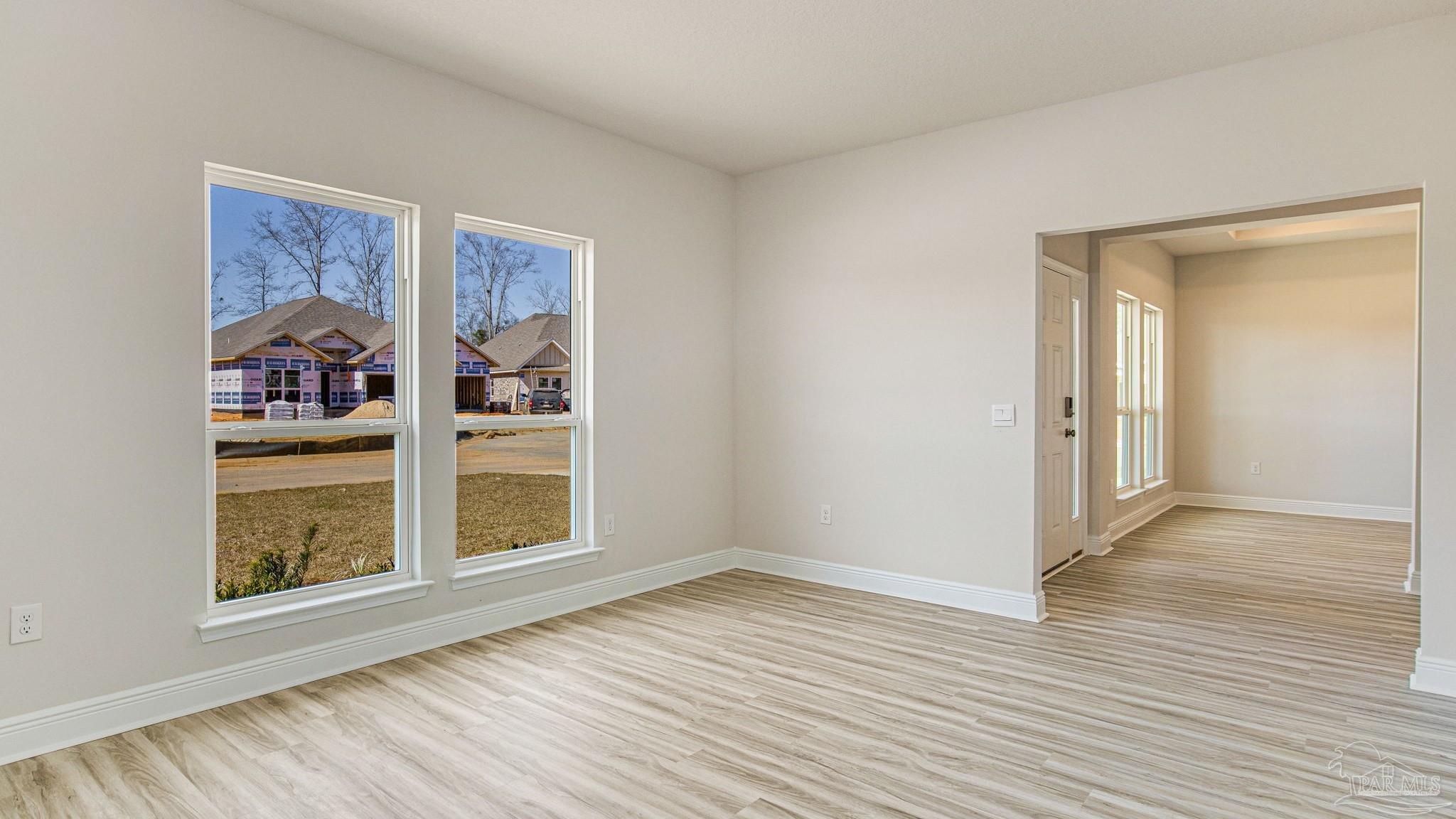 3472 Crossvine Road Cantonment, FL 32533 - Photo 6 of 23 a view of an empty room with wooden floor and a window