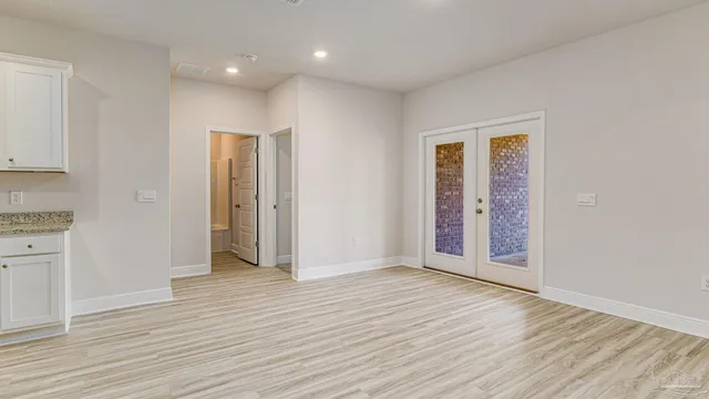an empty room with wooden floor & closet area