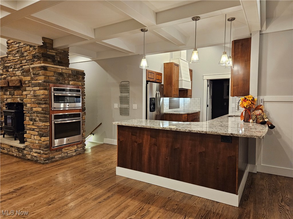 6155 Beach Road Wadsworth, OH 44281 - Photo 14 of 49 Kitchen with peninsula / breakfast bar, hardwood floors, stone wall with built-in stainless appliances features skylight, adjustable pendant, recessed, and cabinet lighting