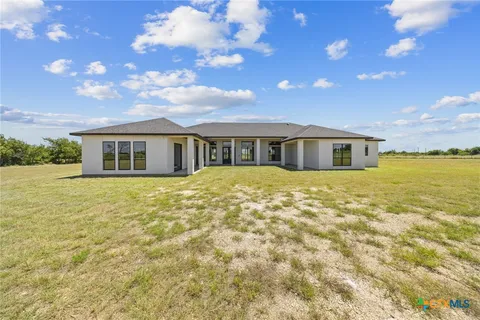 a view of house with a big yard and large trees