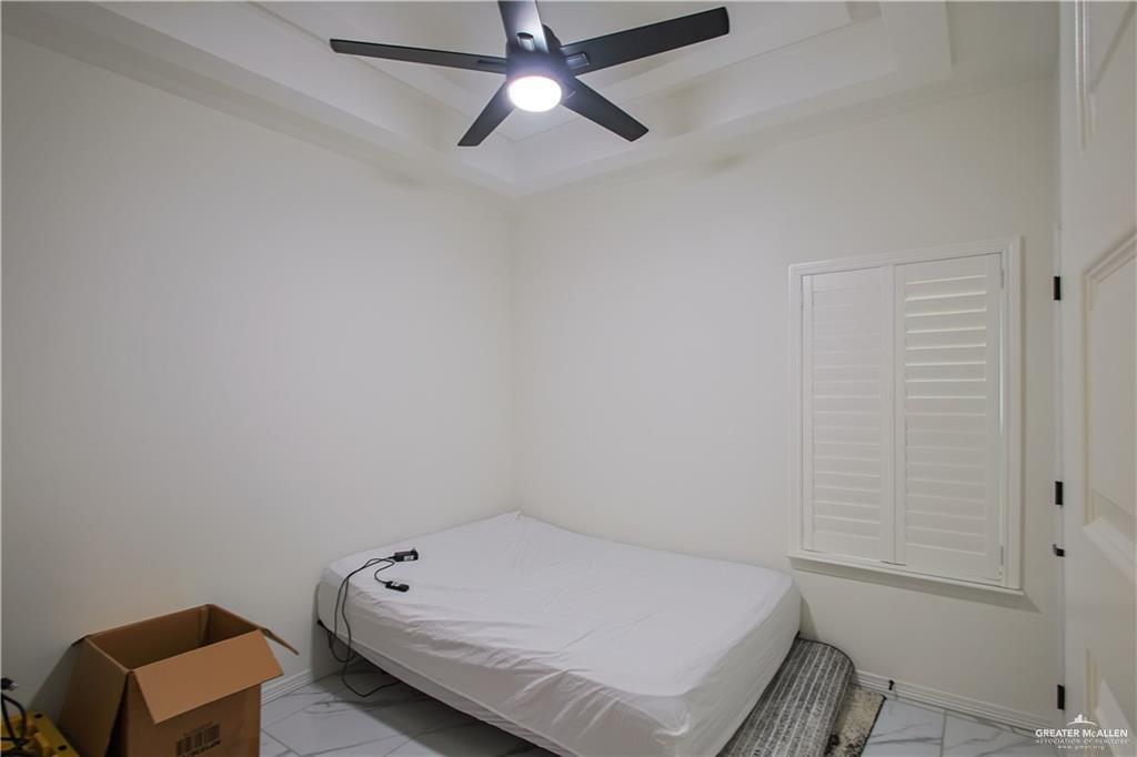 620 Oaxaca Street Alton, TX 78573 - Photo 14 of 23 a bedroom with a bed and a chandelier fan