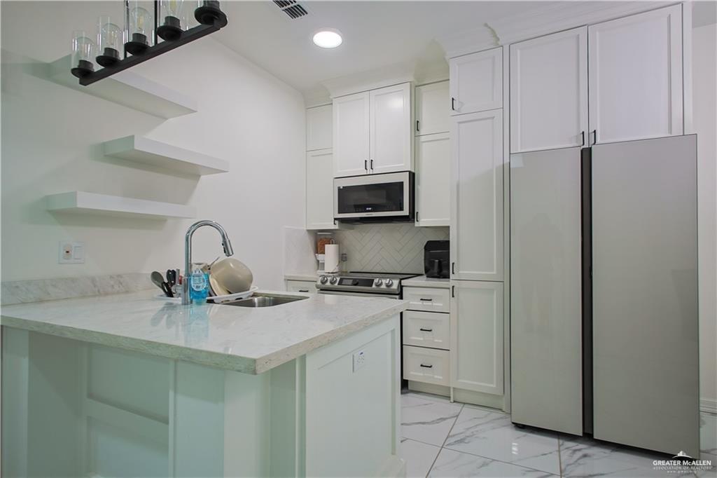 620 Oaxaca Street Alton, TX 78573 - Photo 4 of 23 a kitchen with stainless steel appliances granite countertop a sink stove and refrigerator
