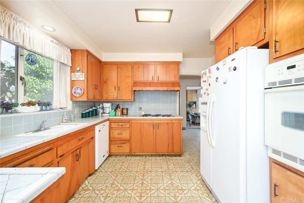 9505 Raviller Drive Downey, CA 90240 - Photo 20 of 54 a kitchen with stainless steel appliances a refrigerator sink and cabinets