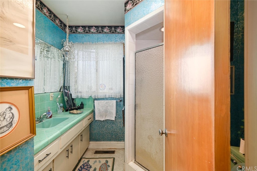 9505 Raviller Drive Downey, CA 90240 - Photo 24 of 54 a bathroom with a granite countertop sink a mirror and shower