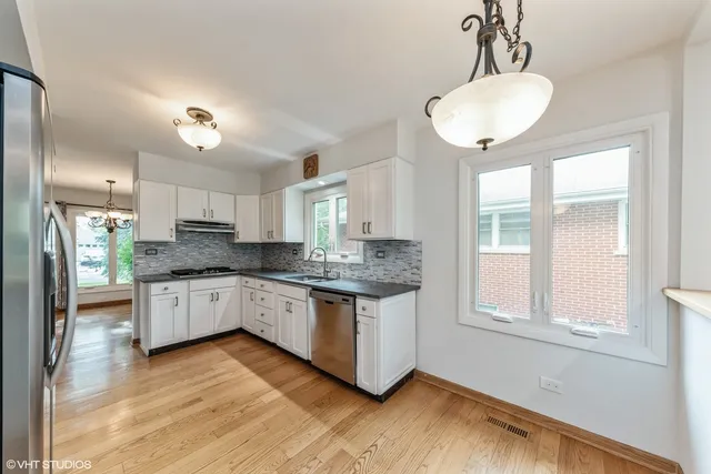 a kitchen with stainless steel appliances granite countertop a stove a sink and a refrigerator