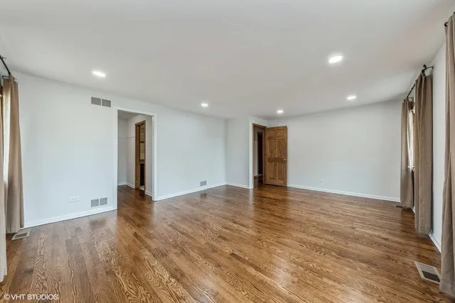 a view of an empty room with wooden floor