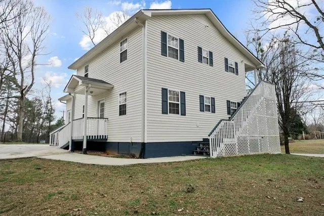 a view of a white house with a yard