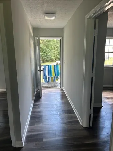a view of a hallway with wooden floor and stairs