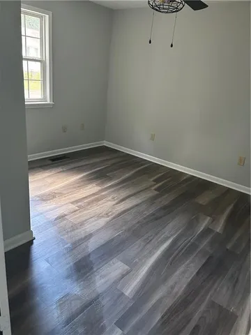 a view of a room with wooden floor and a window