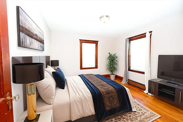 a bedroom with a bed and wooden floor