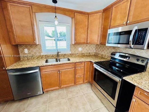 3147 Trevino Terrace, Unit 2 Punta Gorda, FL 33983 - Photo 3 of 24 a kitchen with stainless steel appliances granite countertop a sink stove and microwave