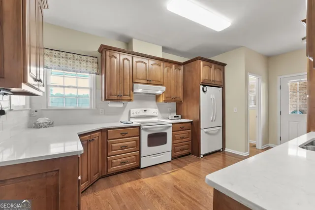 a kitchen with stainless steel appliances granite countertop a stove a sink dishwasher and a refrigerator