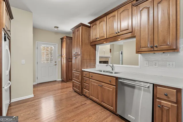 a kitchen with granite countertop wooden cabinets a sink and stainless steel appliances