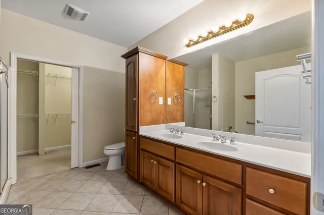 a spacious bathroom with a double vanity sink mirror and toilet