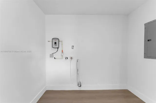 an empty room with wooden floor and window