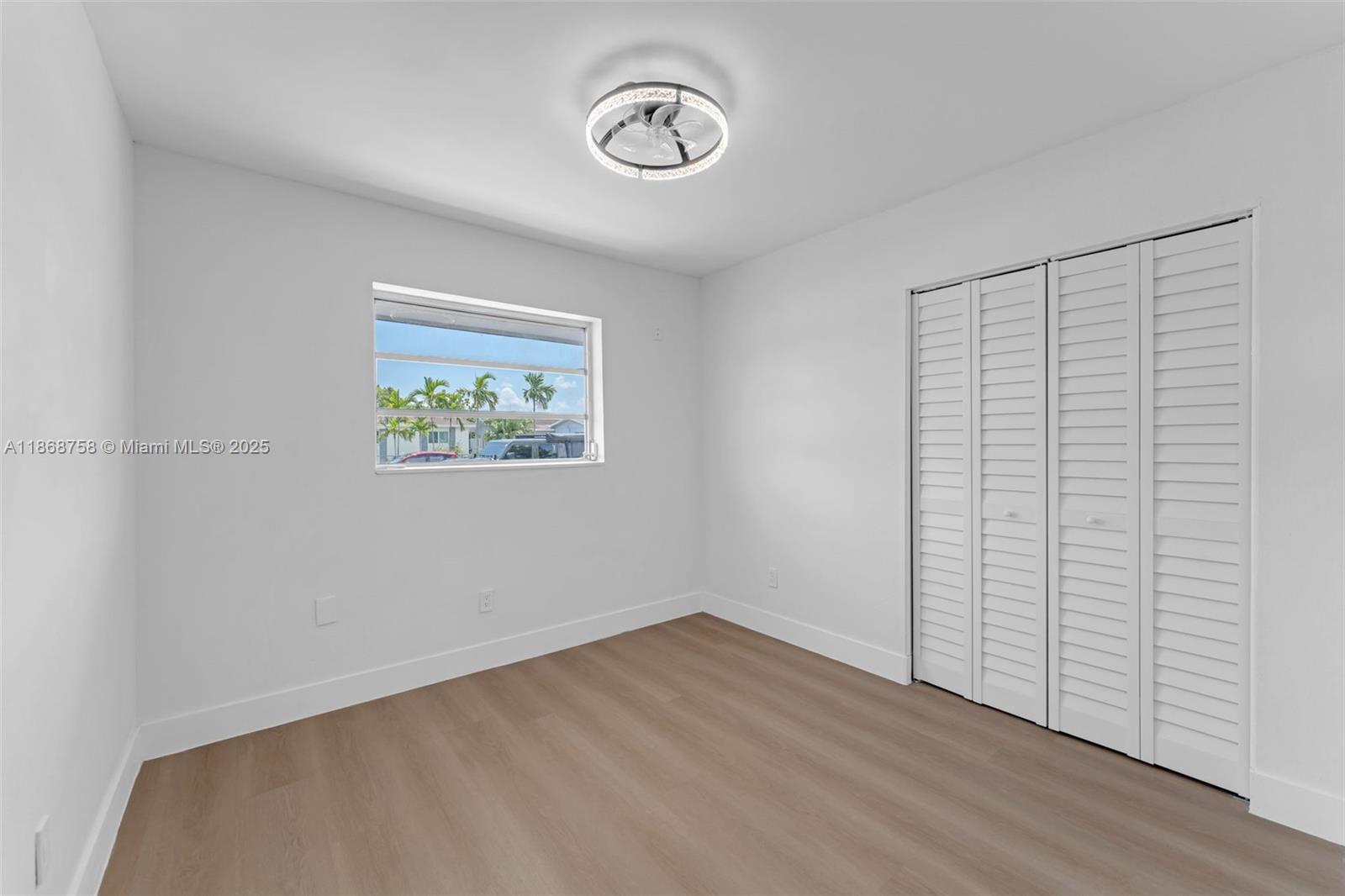 11711 Southwest 181st Terrace Miami, FL 33177 - Photo 12 of 35 an empty room with wooden floor and window