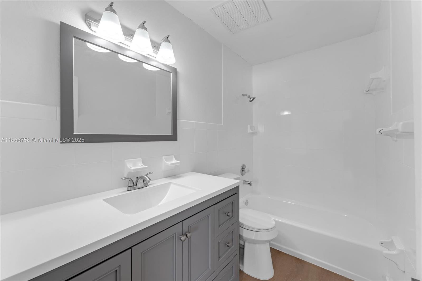 11711 Southwest 181st Terrace Miami, FL 33177 - Photo 14 of 35 a bathroom with a double vanity sink toilet and a mirror