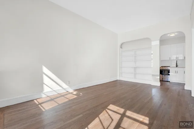 a kitchen with granite countertop a refrigerator and a stove top oven