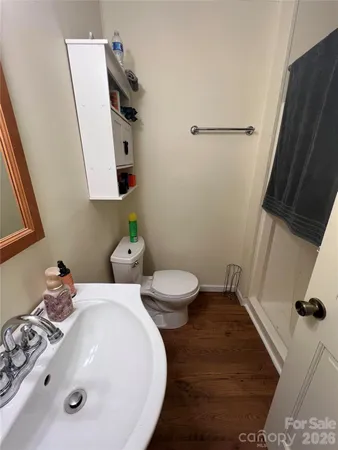 a bathroom with a sink and mirror with toilet