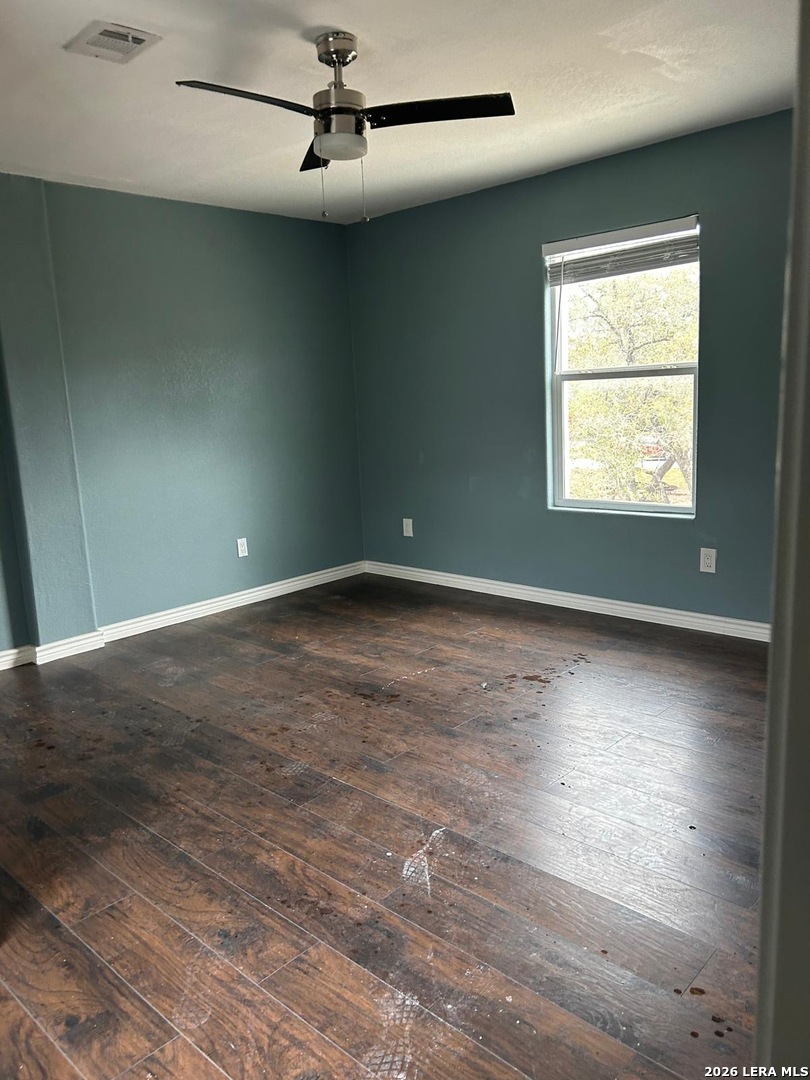 174 Red Fox Poteet, TX 78065 - Photo 9 of 9 an empty room with wooden floor fan and windows