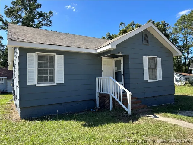 a front view of a house with plants