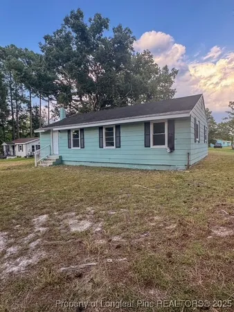 a view of a house with yard and a tree