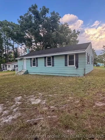 a view of a house with yard and a tree