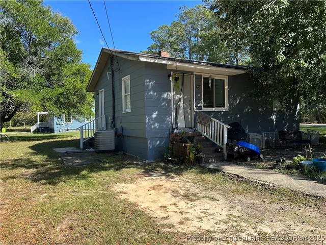 a view of a house with a yard and deck