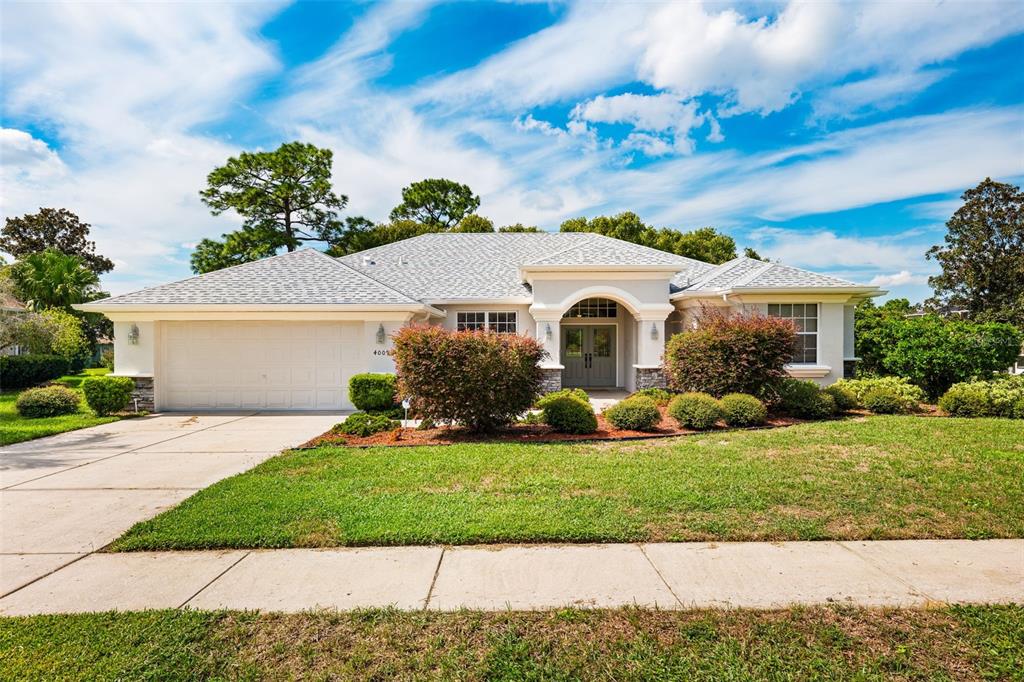 4009 Cedar Crest Loop Spring Hill, FL 34609 - Photo 1 of 1 a view of a white house with a yard and potted plants